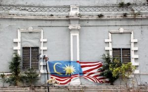 An artistic mural of the Malaysian flag adorns a historic building facade in Kuala Lumpur.